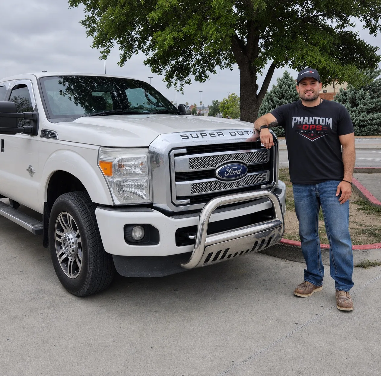 John Salinas standing next to a white Ford Super Duty truck in Phantom Ops Hauling apparel